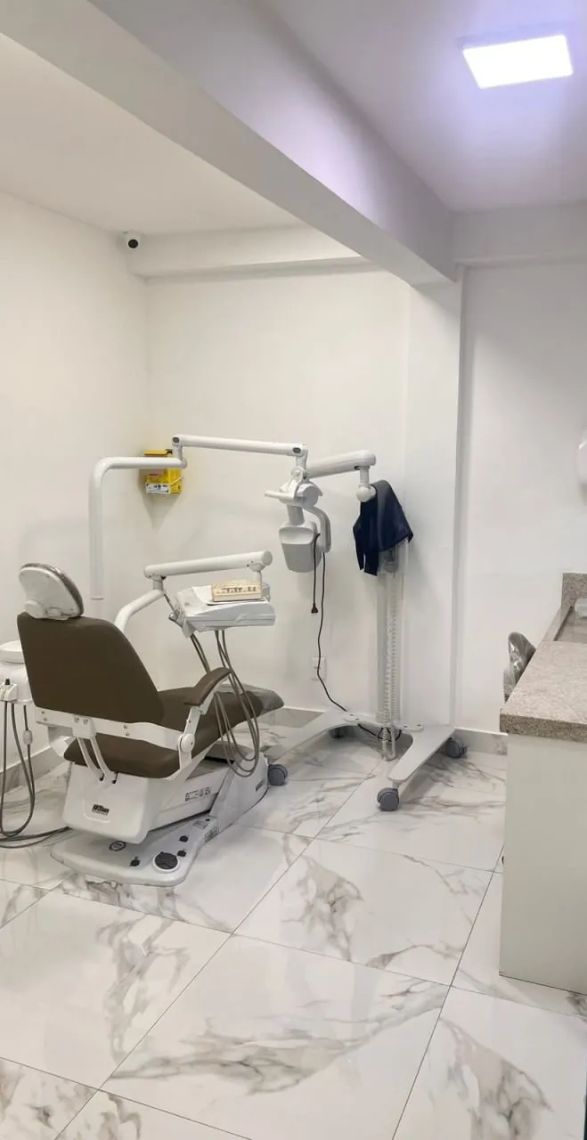 Consultório odontológico com cadeira e equipamento de atendimento
